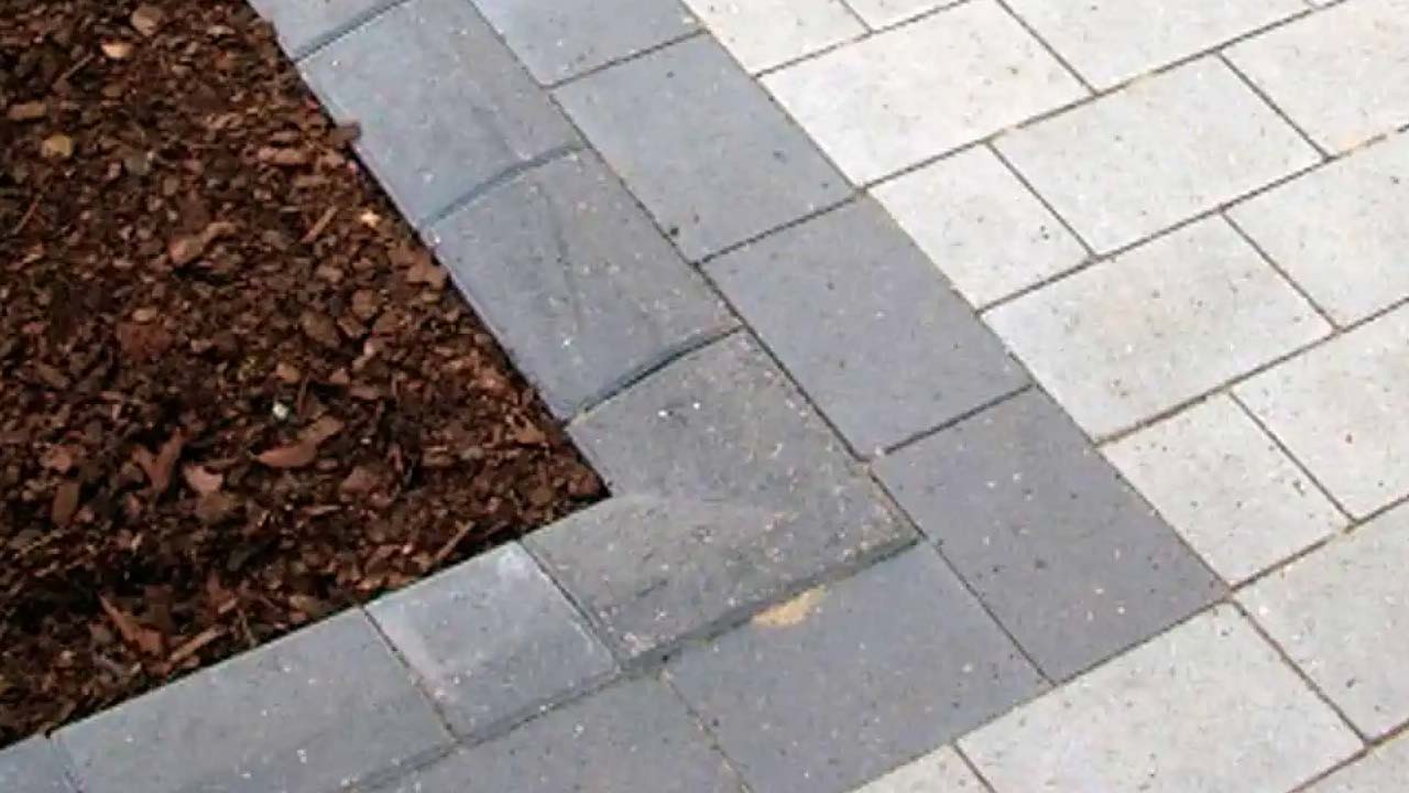 Kantblok der afgr&aelig;nser terrasse og bed med barkflis