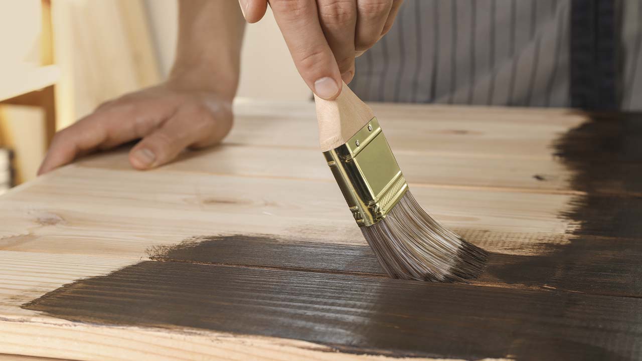 Træplanker der får mørkebrun træbeskyttelse